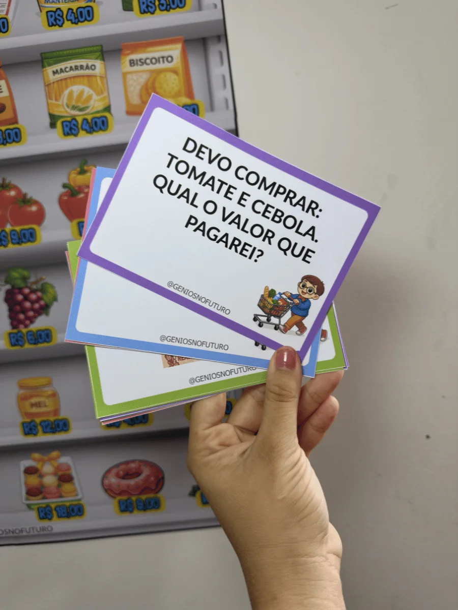 Cartões de desafios do Supermercado da Matemática sendo segurados diante da prateleira